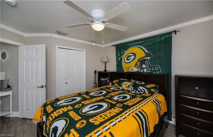 Bedroom with a closet, ornamental crown molding, and ceiling fan