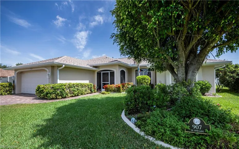 Single story home featuring a garage and nice curb appeal landscaping