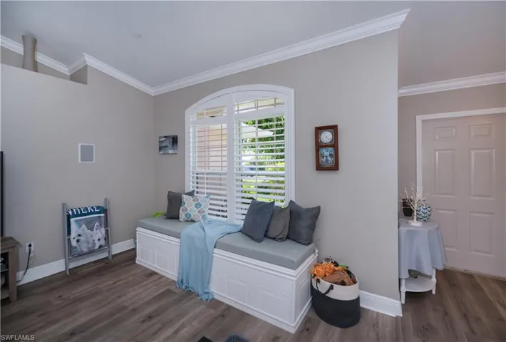 Living area with crown molding, window seat and plantation shutters