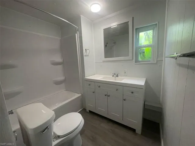 Full bathroom featuring bathtub / shower combination, vanity, toilet, and hardwood / wood-style floors