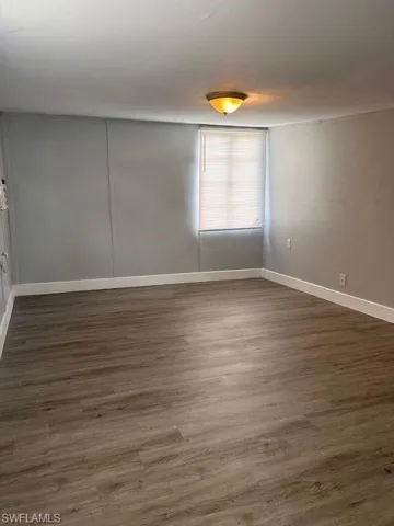 Spare room featuring dark wood-type flooring