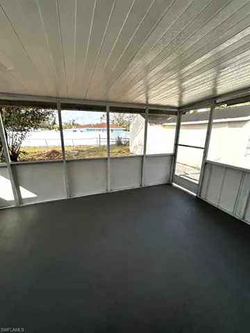 Unfurnished sunroom featuring a wealth of natural light, wooden ceiling, and a water view
