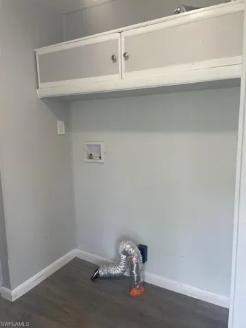 Laundry area featuring dark hardwood / wood-style floors and washer hookup