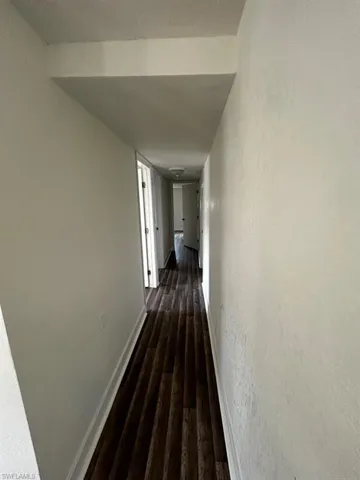 Corridor with dark hardwood / wood-style floors