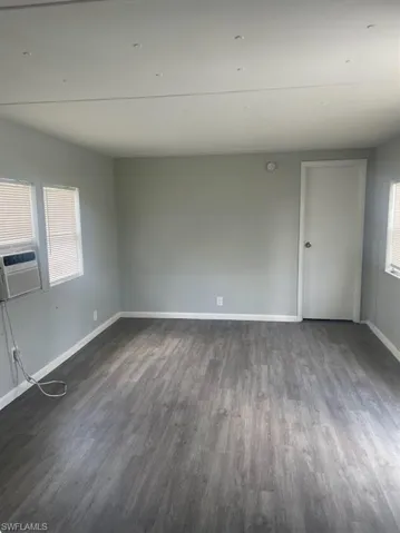 Unfurnished room with cooling unit and dark hardwood / wood-style floors