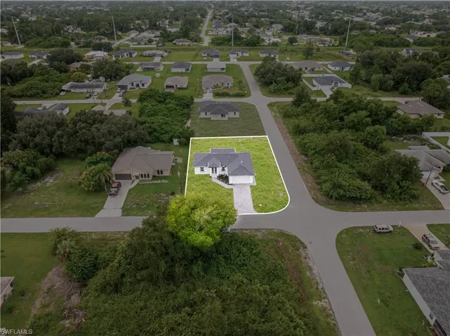 Single-story residence featuring a shingled roof, a paved driveway, and a corner lot configuration