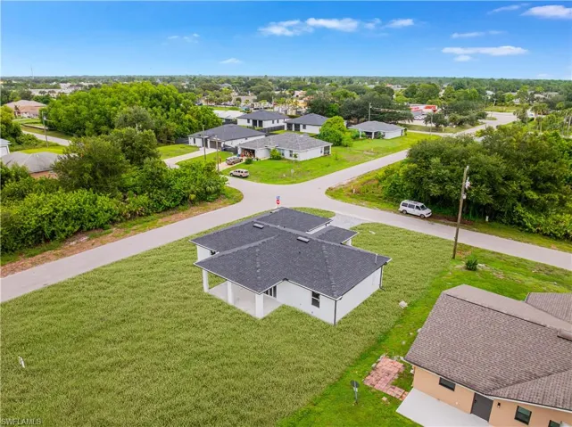 Aerial perspective of a single-story residence featuring a dark shingle roof and a covered rear patio with structural columns