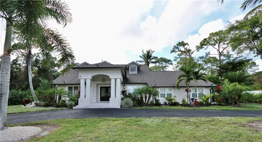 View of front of home with a front yard, stucco siding, and a shingled roof