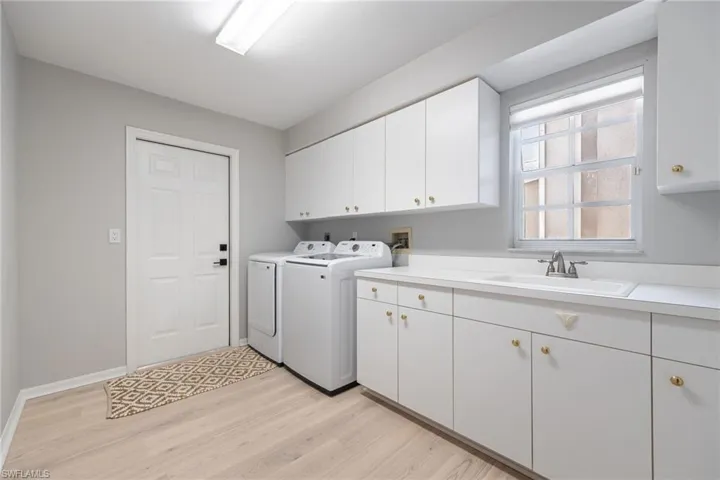 Laundry room with abundance of cabinets. This could be your extra pantry space! Utillity sink and counter tops to fold clothes or work on projects.