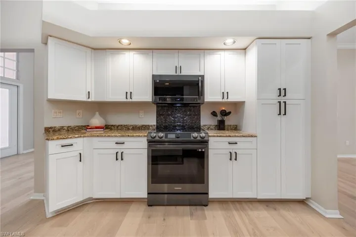 Slide in self cleaning stove and microwave. View of access to front entrance from the Kitchen on left. Such great storage in this kitchen!