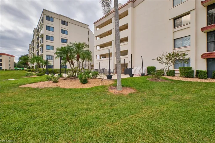 Rear view of the condo building featuring lots of green space.