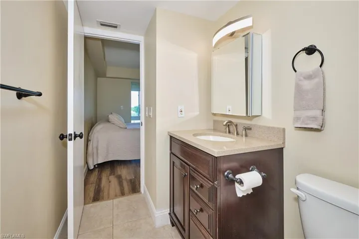 Bathroom with vanity, light tile patterned flooring, and en-suite bath.