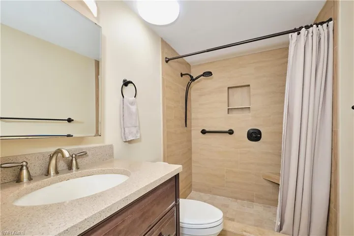 Full bath featuring vanity and tiled shower.