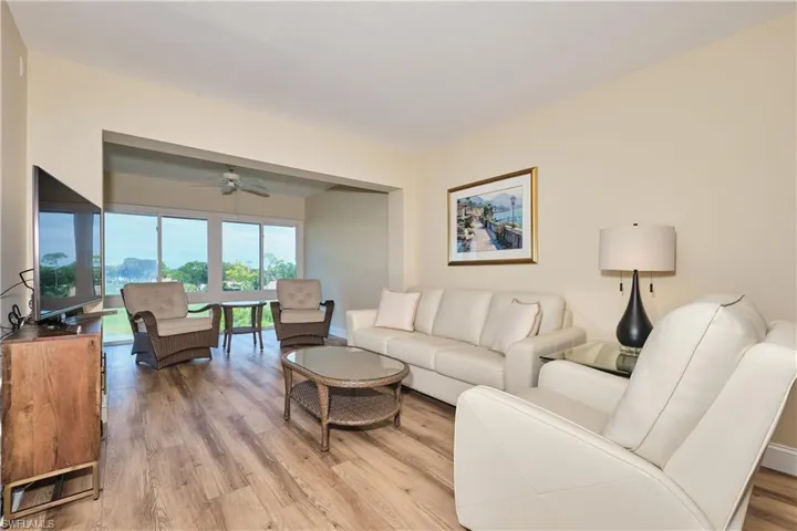 Living area with light wood finished floors and ceiling fan