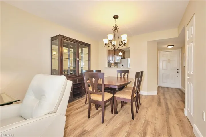 Dining space featuring light wood-style laminate floors and a chandelier.