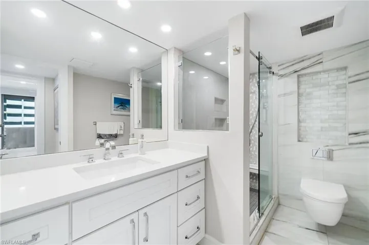 Bathroom with walk in shower, vanity, tile patterned flooring, and toilet