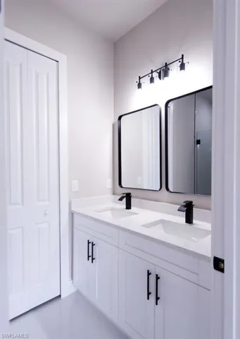 Full bathroom with double vanity and light tile patterned floors