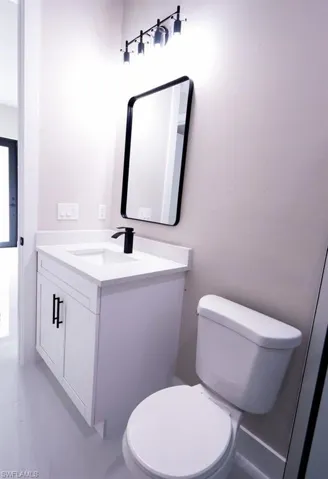 Half bathroom with vanity and light marble finish floors
