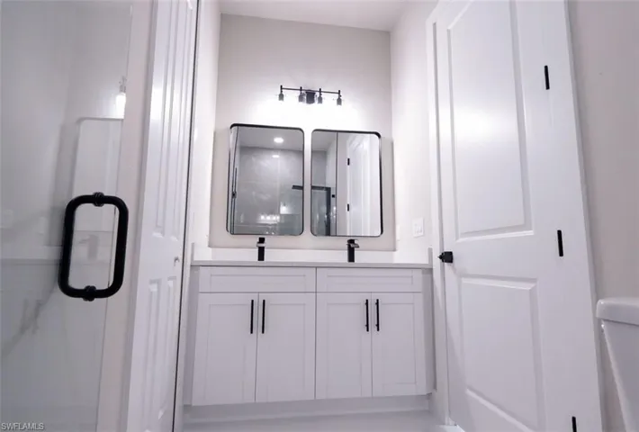 Bathroom featuring double vanity and a stall shower