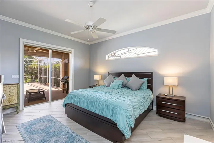 Bedroom with access to exterior pool area, ornamental molding, a ceiling fan and baseboards