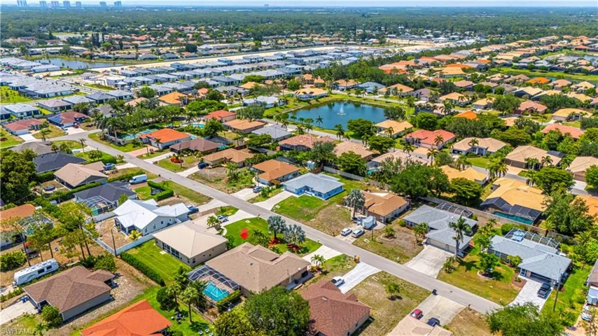 Aerial view of property and surrounding area with a large body of water and nearby suburban area