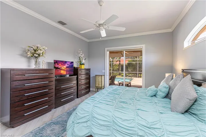 Bedroom featuring access to exterior pool area, multiple windows, light wood-style tile flooring, ornamental molding and ceiling fan