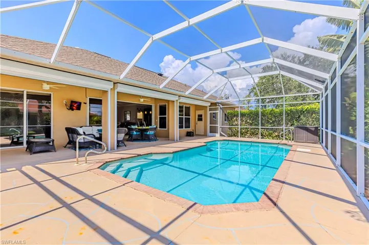 View of pool featuring a patio area, 2 ceiling fans, outdoor lounge area and screen enclosure