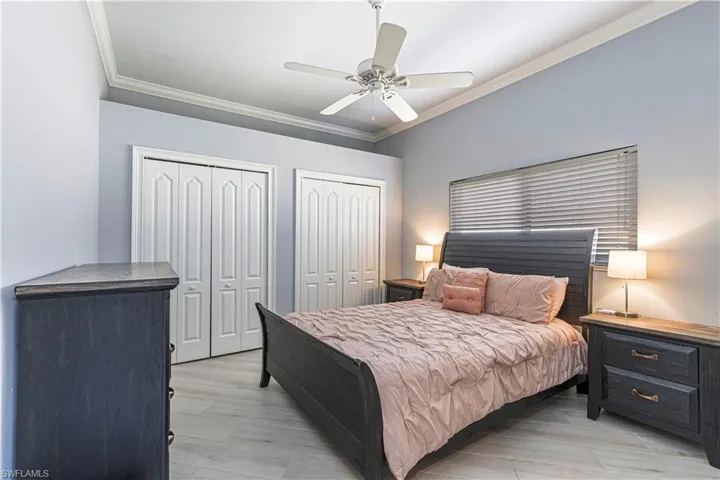 Bedroom featuring ornamental molding, two closets and ceiling fan