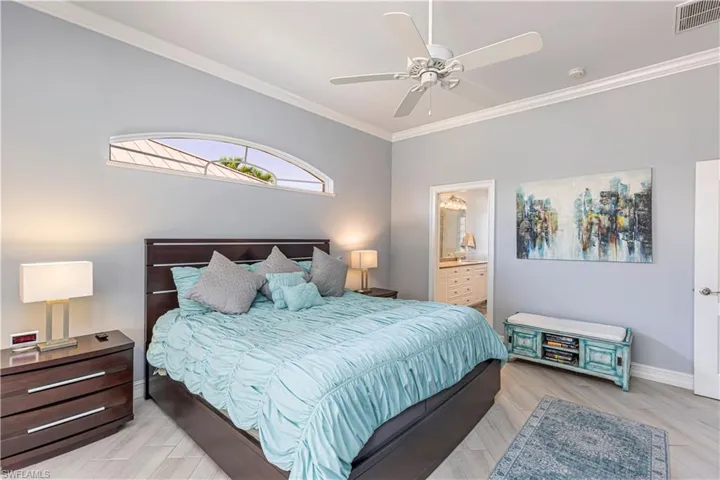 Bedroom featuring baseboards, ornamental molding, a ceiling fan and ensuite bathroom