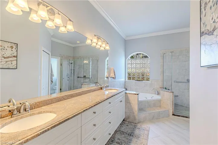 Full bath with double vanity, a garden tub, a shower stall, tile patterned floors and toilet room