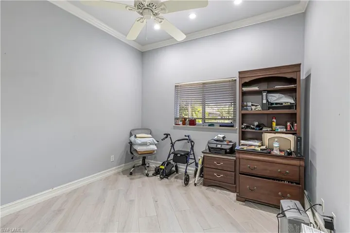 Office area with light wood-style flooring, ceiling fan, crown molding, baseboards, and recessed lighting