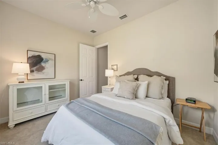 Bedroom with light carpet and a ceiling fan
