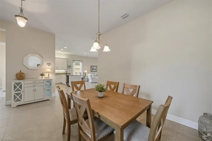 Dining room featuring light tile patterned floors, recessed lighting, and a chandelier