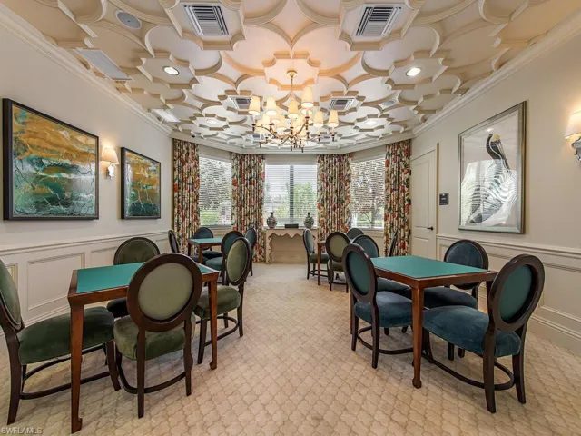 Dining area with a decorative wall, wainscoting, crown molding, carpet floors, and a chandelier