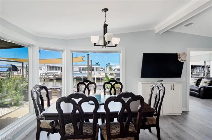 Dining room with crown molding, light wood-type flooring, and a chandelier