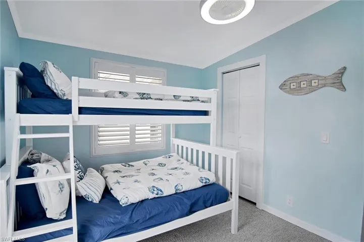 Carpeted bedroom with ornamental molding, a closet, and vaulted ceiling