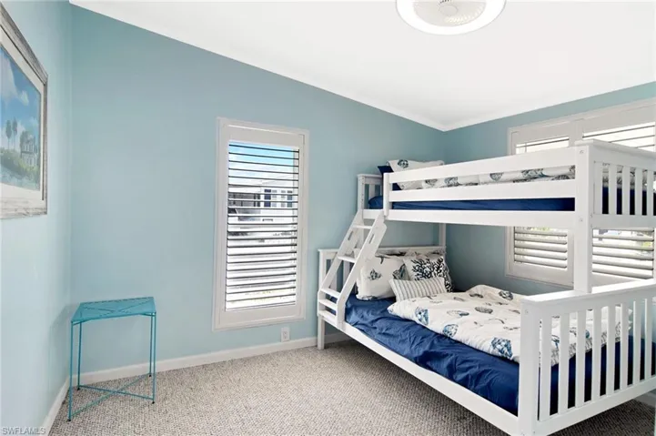 Carpeted bedroom featuring crown molding and baseboards