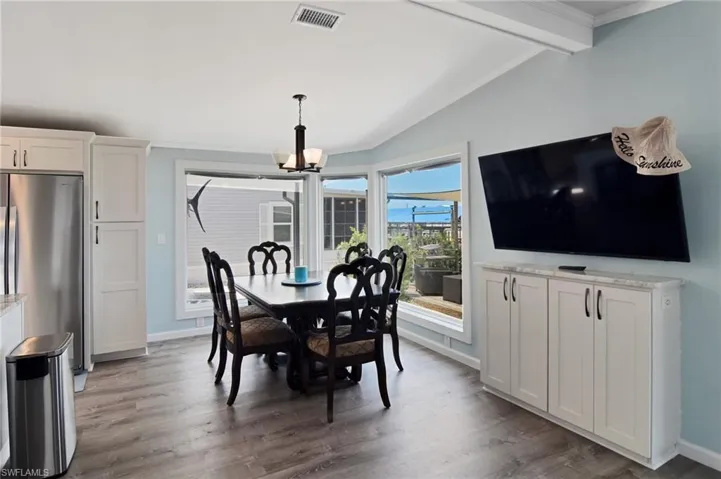 Dining room featuring light wood-type flooring, a chandelier, and ornamental molding
