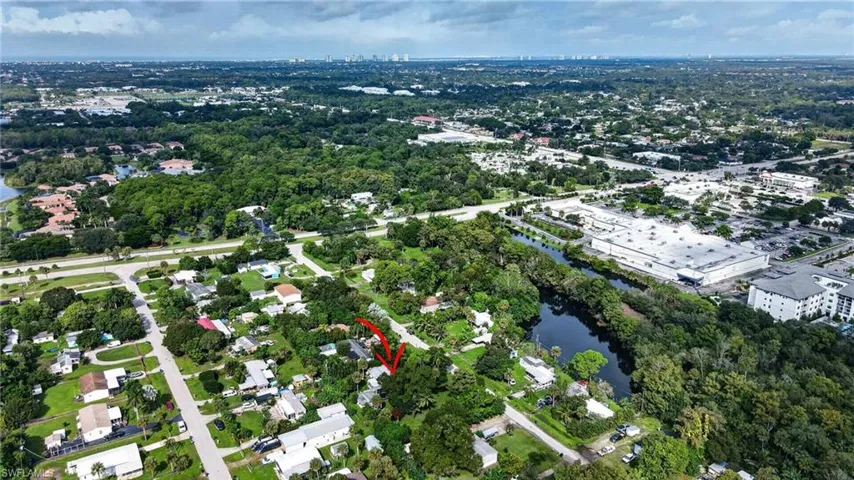 Aerial perspective of property featuring dense mature landscaping, established tree canopy, and proximity to regional water features
