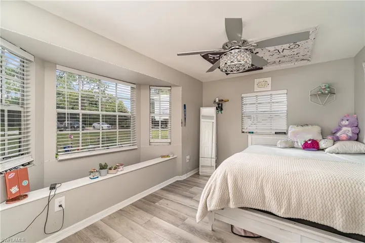 Bedroom 3 featuring multiple windows, ceiling fan, and light hardwood / wood-style flooring