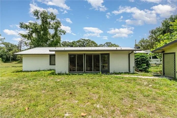 Back of property featuring a lawn