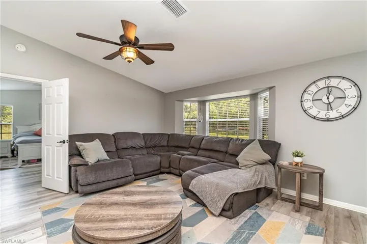 Living room with ceiling fan light hardwood / wood-style flooring