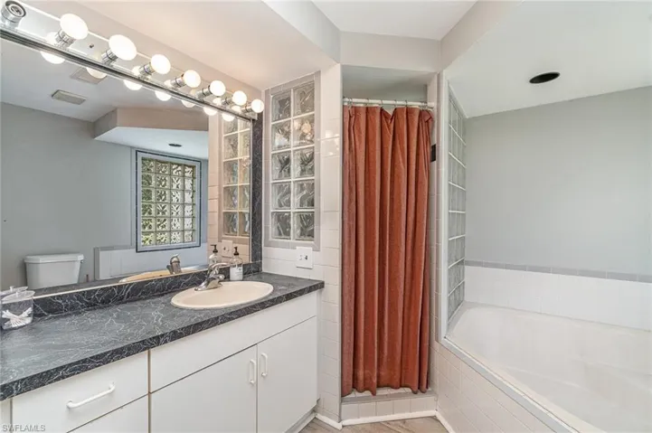 Main on-suite with vanity with extensive cabinet space, tiled shower