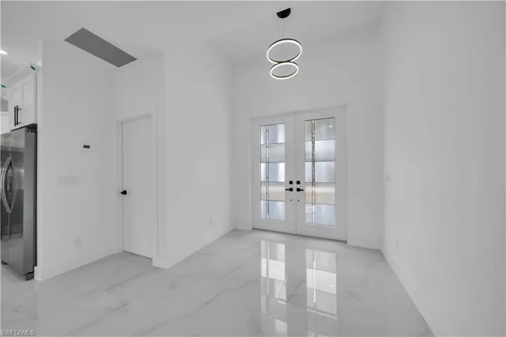 Unfurnished dining area featuring french doors and light marble finish flooring