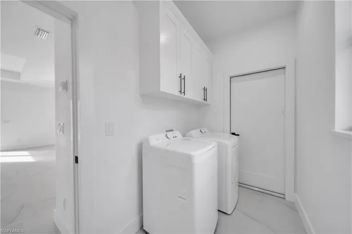 Washroom with cabinet space and washing machine and dryer