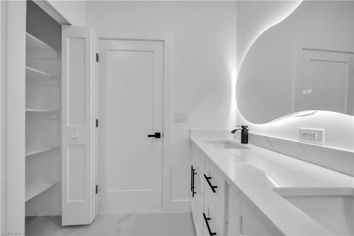 Bathroom featuring double vanity and a closet