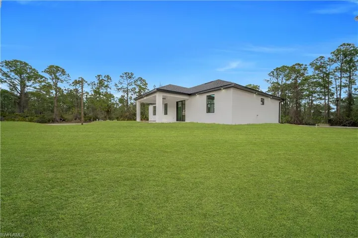 View of home's exterior featuring a lawn, stucco siding, and a patio