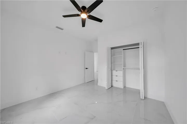 Unfurnished bedroom with a closet and a ceiling fan