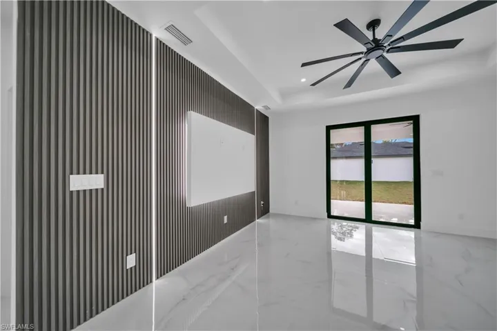 Unfurnished room featuring a ceiling fan, recessed lighting, light marble finish floors, and a raised ceiling