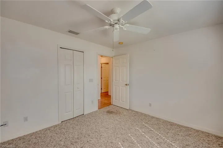 Unfurnished bedroom with a closet, ceiling fan, and carpet